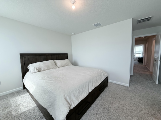 carpeted bedroom with a textured ceiling