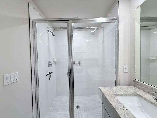 bathroom featuring a shower with door and vanity