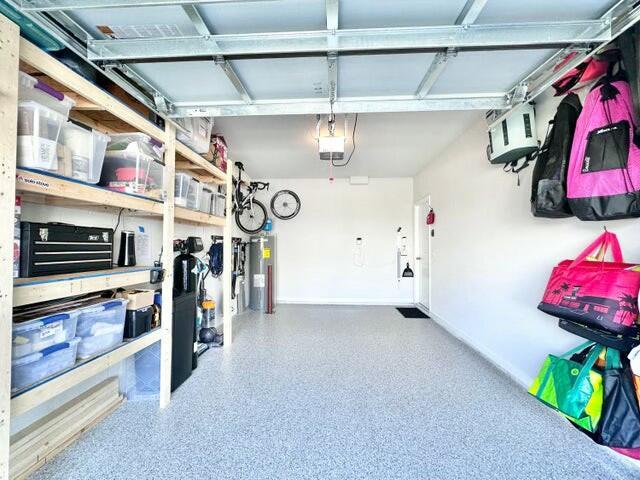 garage with a garage door opener and electric water heater