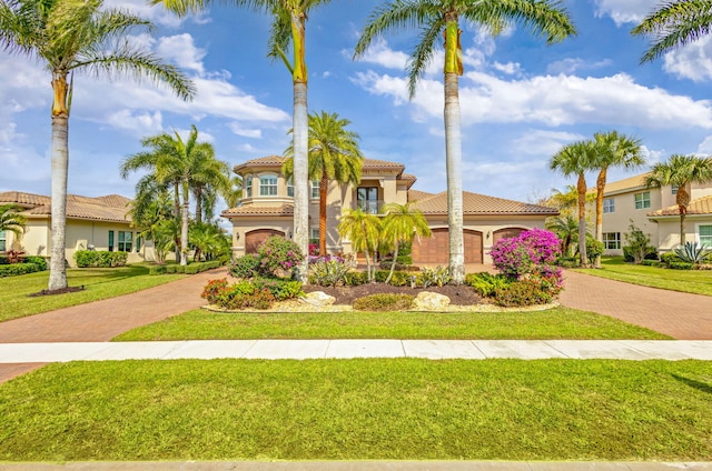 mediterranean / spanish-style house featuring a garage and a front lawn