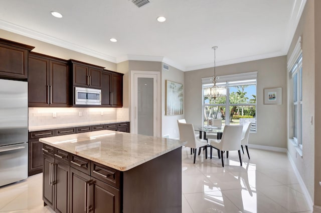 kitchen featuring appliances with stainless steel finishes, decorative light fixtures, a center island, and light tile patterned floors