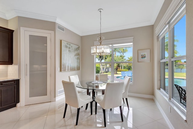 tiled dining space with crown molding, a water view, and a wealth of natural light