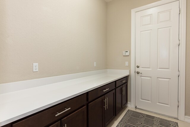 laundry area with cabinets, sink, light tile patterned floors, and washer and clothes dryer