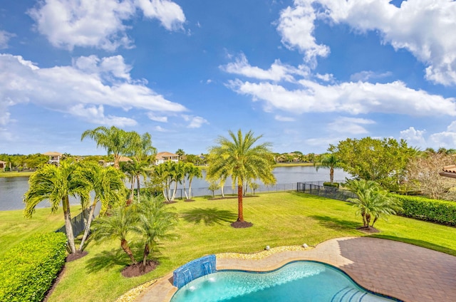 view of pool with a patio area, a lawn, pool water feature, and a water view