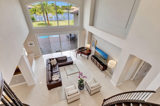 tiled living room featuring a towering ceiling