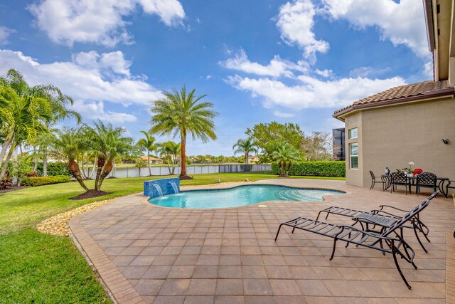 view of swimming pool with a patio area, pool water feature, and a water view