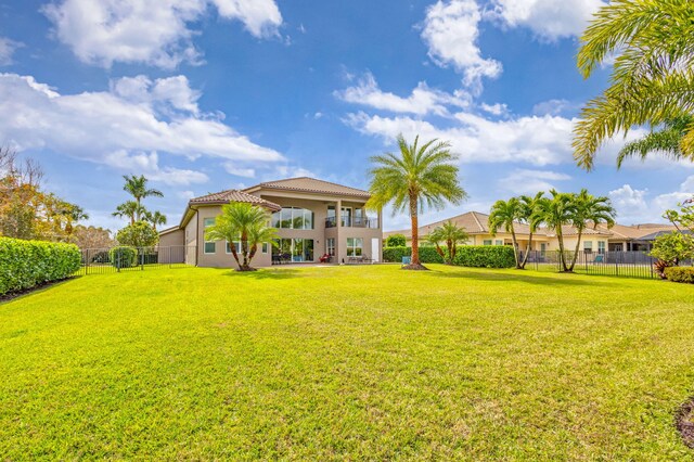 back of property with a fenced in pool, a yard, and a patio area