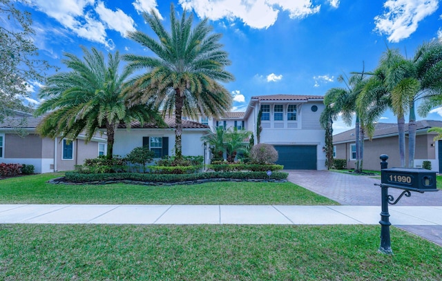 mediterranean / spanish house with a garage and a front lawn