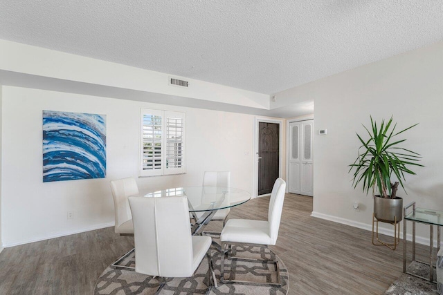 dining room with dark hardwood / wood-style flooring and a textured ceiling