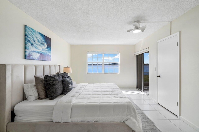 bedroom featuring light tile patterned floors, a textured ceiling, and ceiling fan