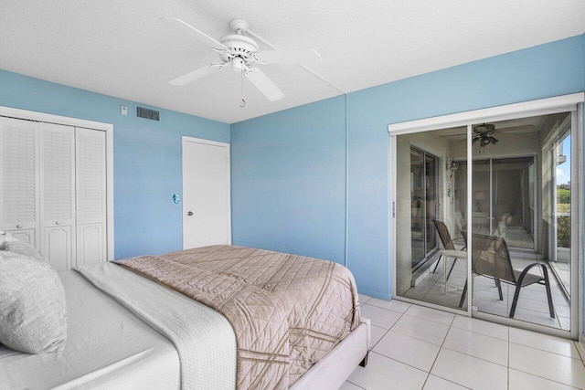 bedroom with light tile patterned floors, a textured ceiling, ceiling fan, and a closet