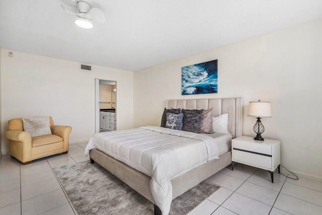 bedroom with ensuite bathroom and light tile patterned floors