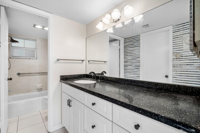 full bathroom featuring tile patterned floors, toilet, tiled shower / bath combo, and vanity