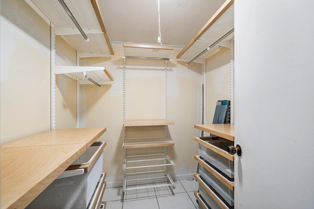 walk in closet with light tile patterned floors