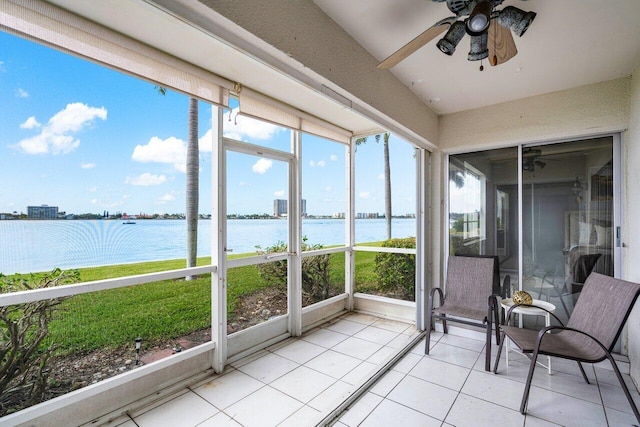 unfurnished sunroom with ceiling fan and a water view