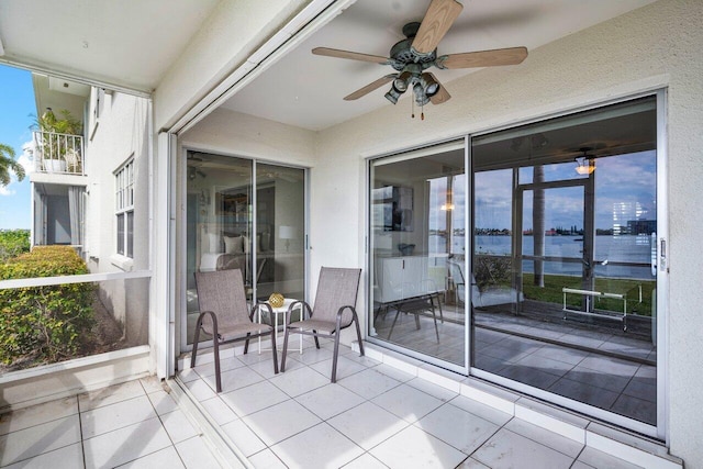 exterior space with ceiling fan and a water view