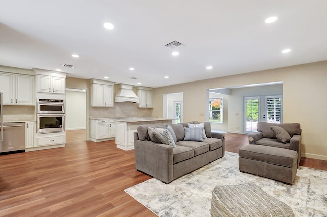 living room with light hardwood / wood-style flooring and french doors