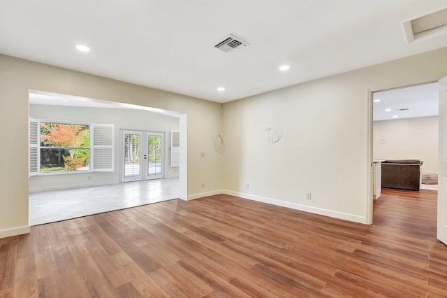 spare room with hardwood / wood-style floors and french doors