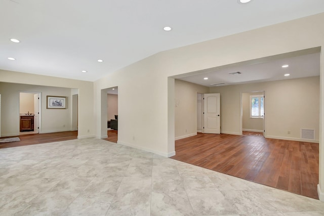 unfurnished room featuring vaulted ceiling and light hardwood / wood-style floors