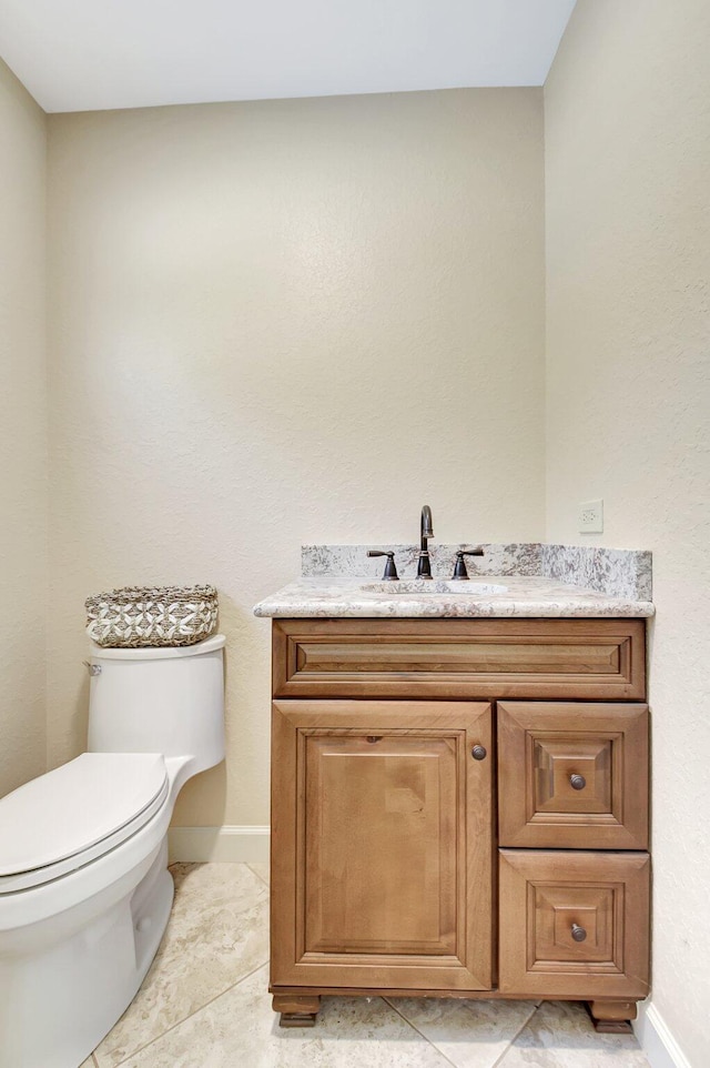 bathroom with vanity, toilet, and tile patterned flooring