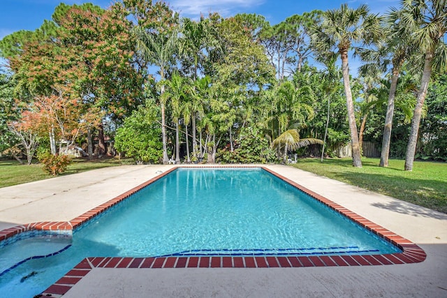 view of pool with a patio area and a lawn