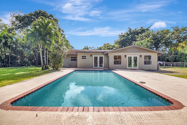 view of pool featuring a yard, a patio area, and french doors