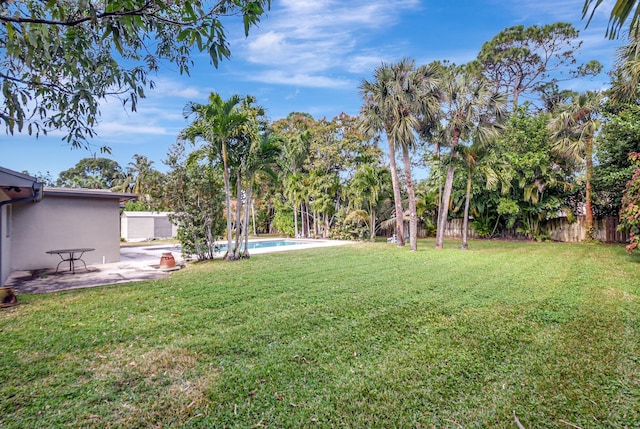 view of yard with a fenced in pool and a patio