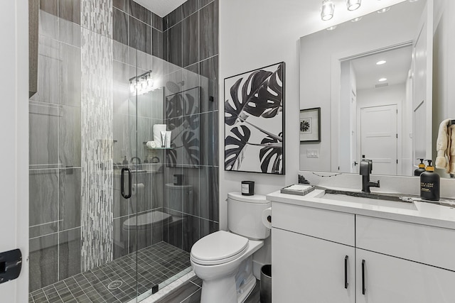 bathroom with vanity, toilet, and a shower with shower door