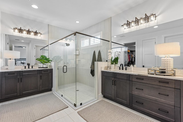 bathroom with tile patterned floors, a shower with door, and vanity