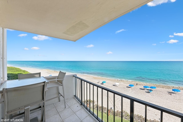 balcony featuring a view of the beach and a water view