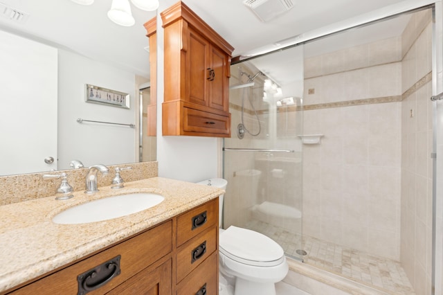 bathroom with vanity, toilet, and a shower with shower door