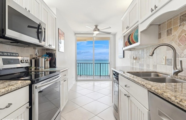 kitchen featuring a water view, white cabinetry, appliances with stainless steel finishes, and sink