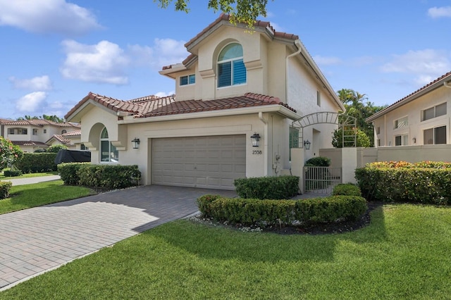 mediterranean / spanish home featuring a garage and a front yard