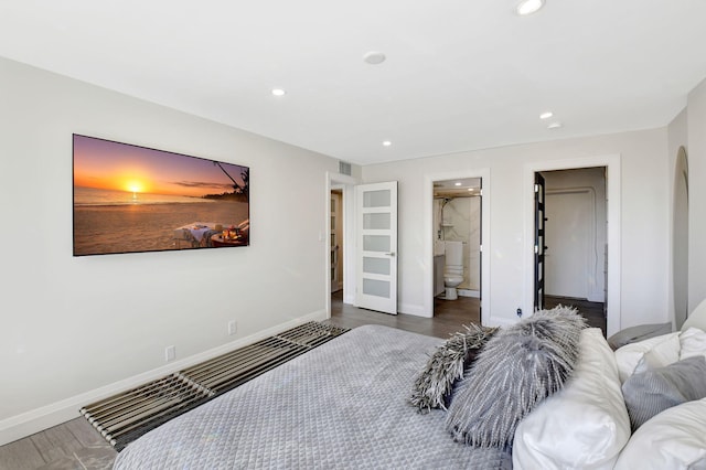 bedroom with dark hardwood / wood-style floors and ensuite bath