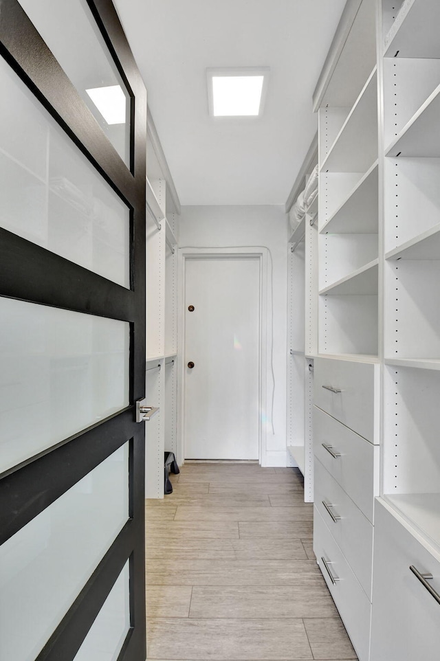 walk in closet with light wood-type flooring