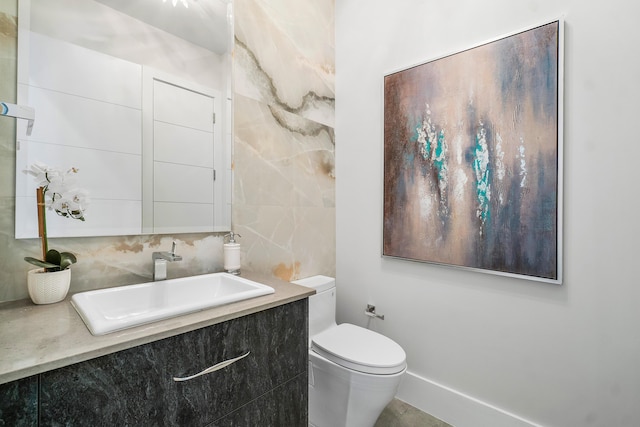 bathroom featuring vanity, toilet, decorative backsplash, and tile walls