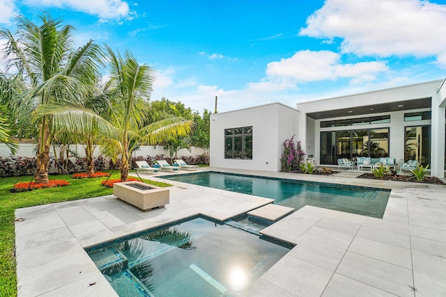 view of swimming pool featuring a jacuzzi, a patio area, and an outdoor fire pit