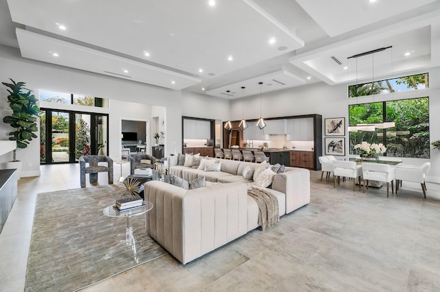 living room featuring french doors, a towering ceiling, and a raised ceiling