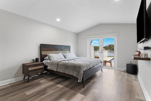 bedroom with french doors, lofted ceiling, a textured ceiling, access to exterior, and hardwood / wood-style floors