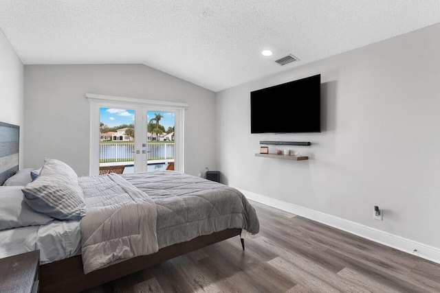 bedroom with french doors, wood-type flooring, vaulted ceiling, and a textured ceiling