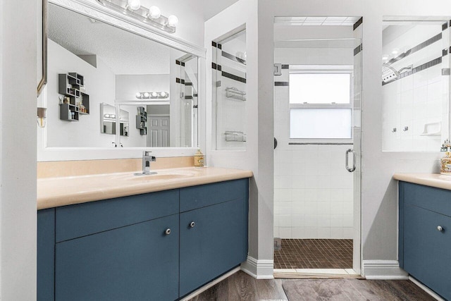 bathroom with vanity, a shower with door, and hardwood / wood-style floors