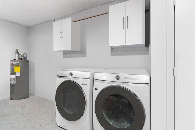 washroom with cabinets, washing machine and dryer, water heater, and a textured ceiling