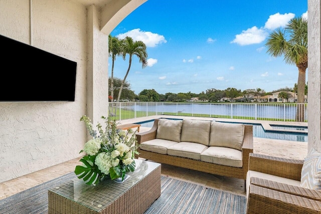 balcony with an outdoor living space, a patio area, and a water view