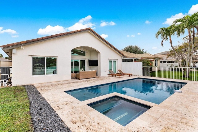 rear view of property with a pool with hot tub, an outdoor hangout area, and a patio area