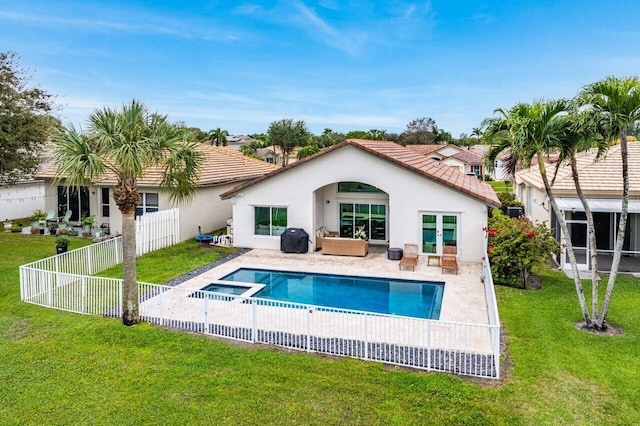 rear view of property featuring a yard, a pool with hot tub, and a patio area