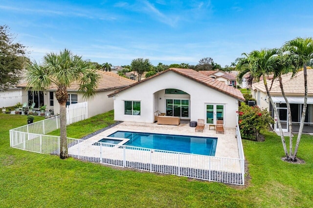 rear view of property with a pool with hot tub, a lawn, and a patio