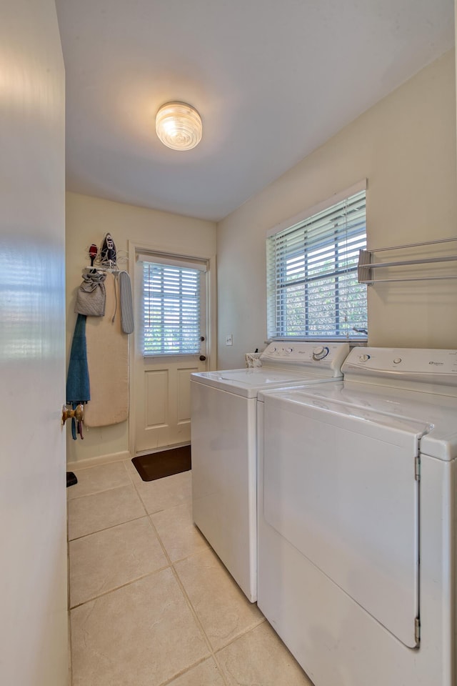 laundry area with light tile patterned floors and washer and dryer