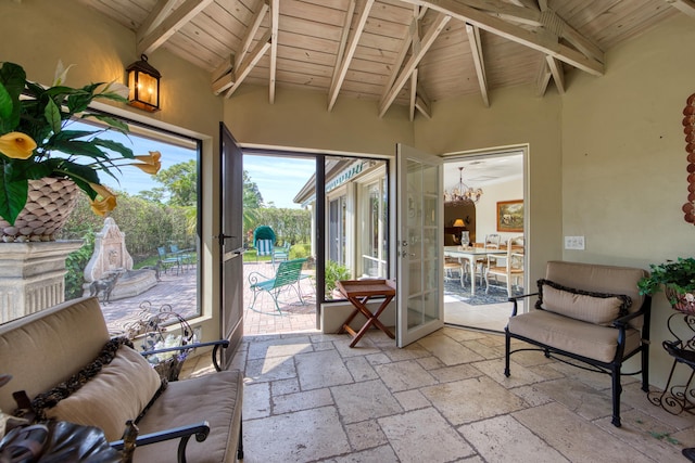 sunroom / solarium featuring vaulted ceiling with beams, wooden ceiling, and french doors