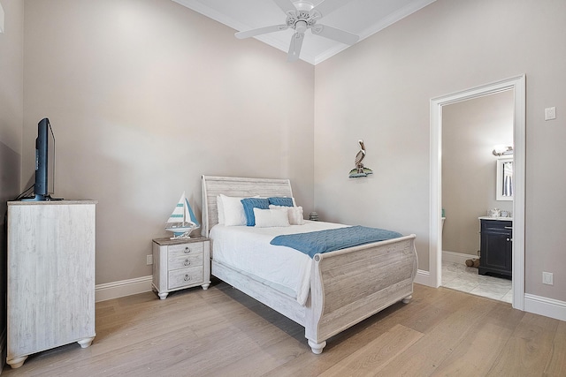 bedroom with light wood-style flooring, baseboards, ensuite bathroom, and ceiling fan