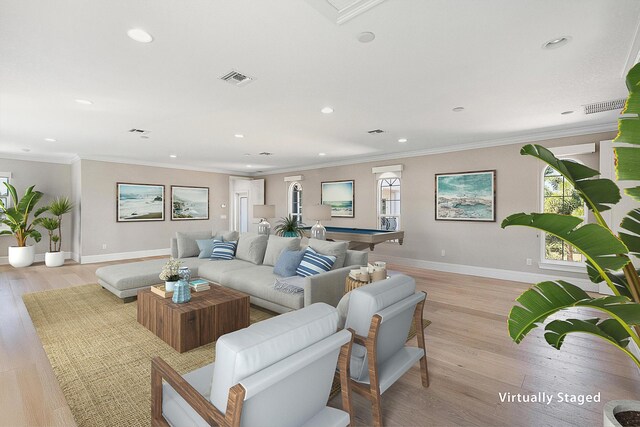 living room featuring crown molding, light wood-type flooring, and baseboards